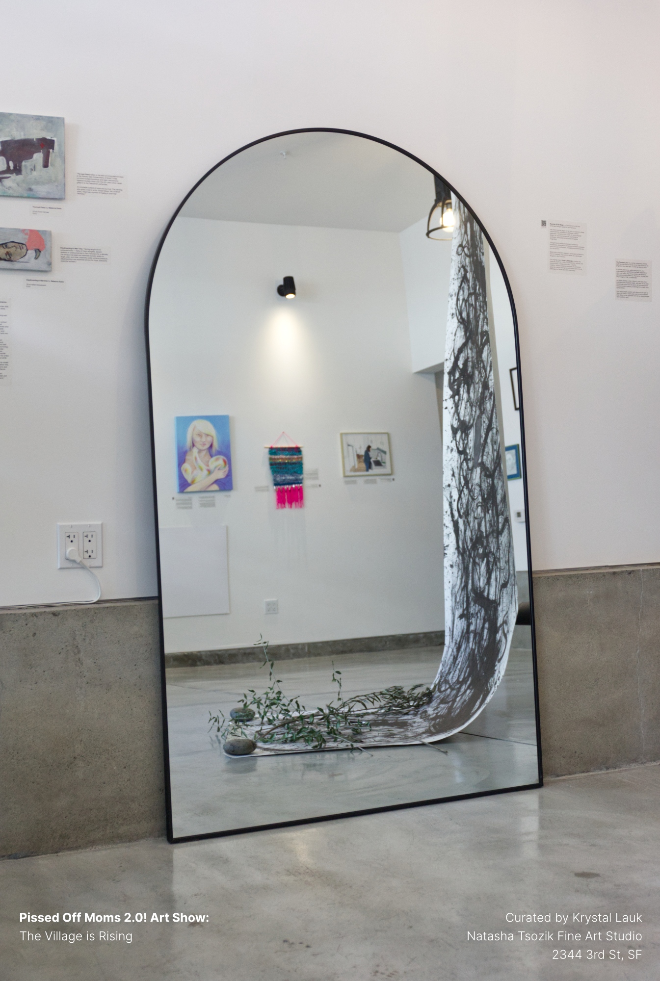 An arched mirror reflecting the gallery, the ink scroll spilling across the floor.