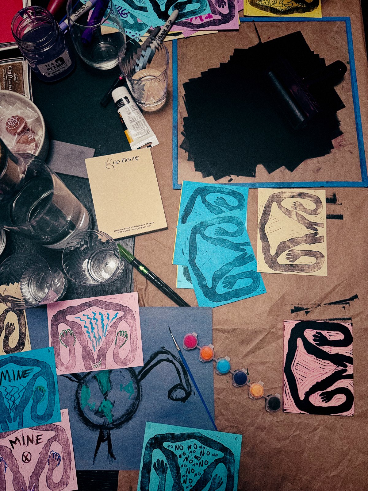 Fresh linocut uturus prints drying among ink, brushes and glasses