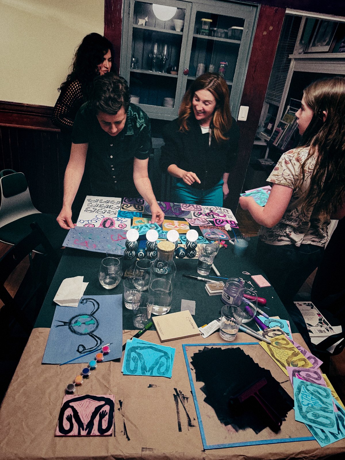 Hands laying out prints together at the worktable